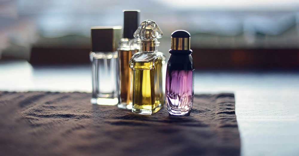 چند شیشه ادکلن در کنار هم بر روی یک پارچه